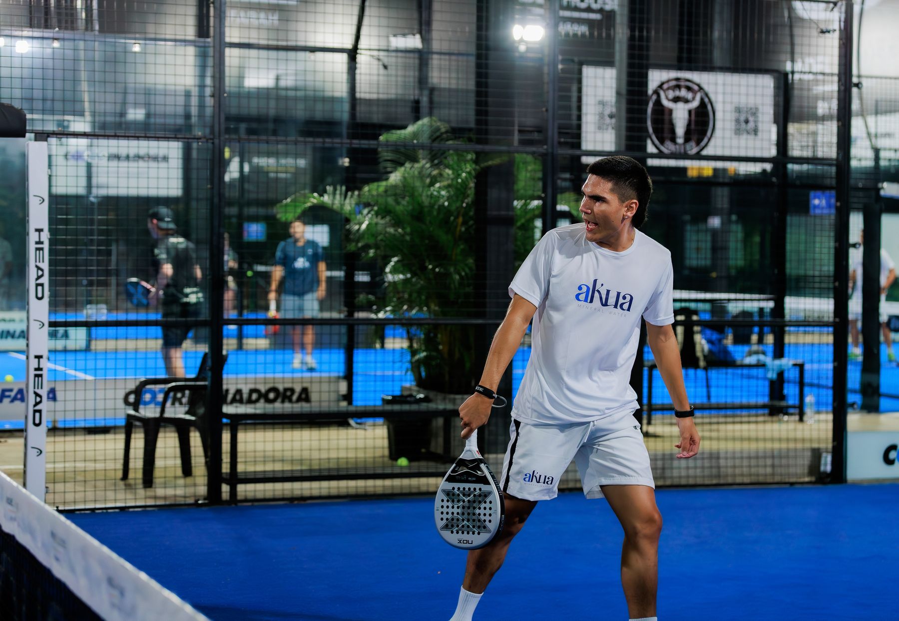 A player mid-rally on an indoor court